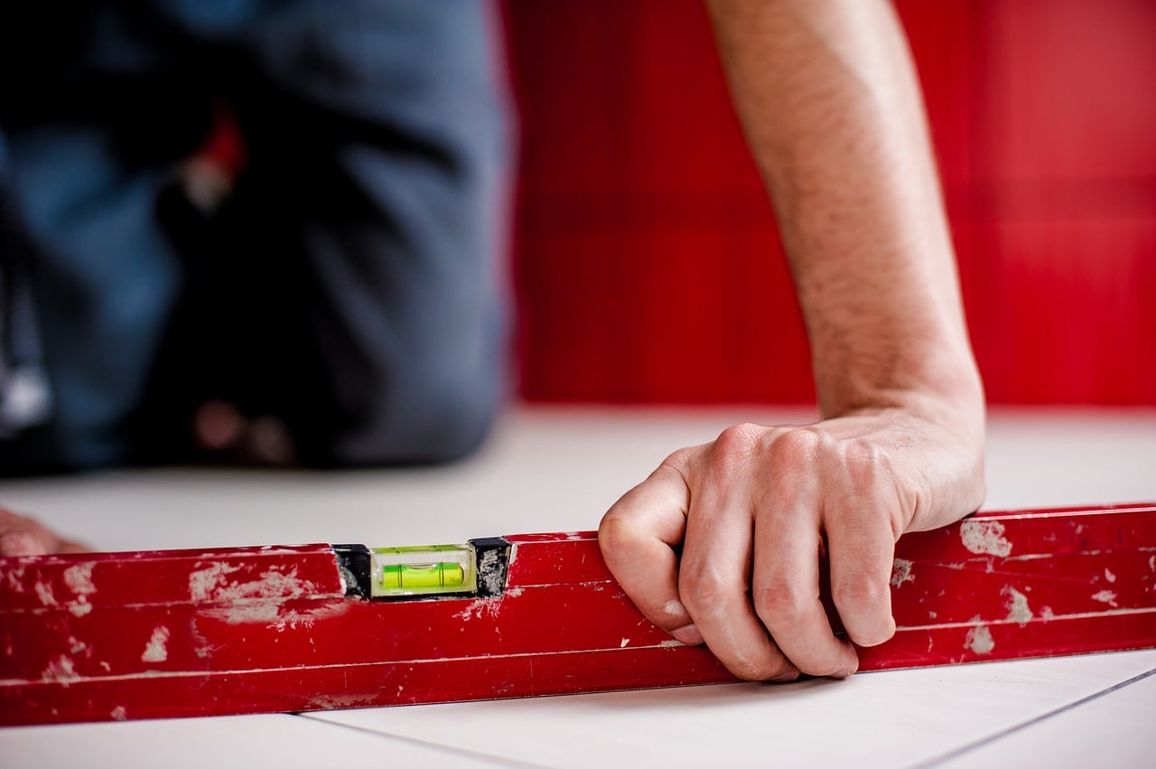 Someone holding a level to see whether the floor is straight