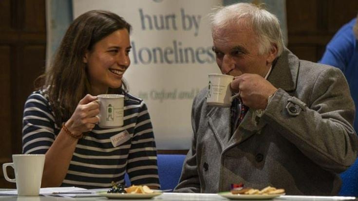 a man and a woman sitting at a table with food and drinks