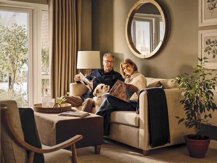 a man and woman sitting on a couch with a dog