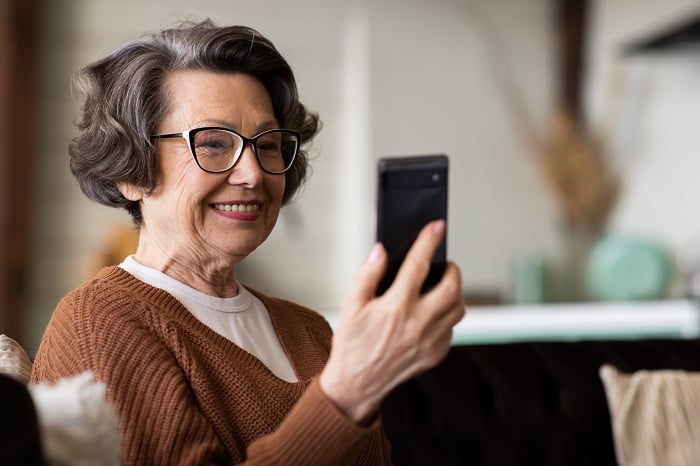 Woman looking at her mobile phone and planning finances
