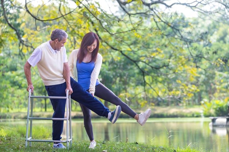 a man and a woman running on a metal railing by a pond