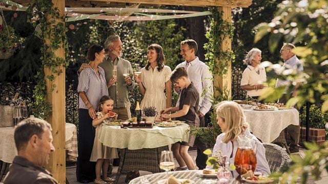 A group of people standing around a table with food on it.