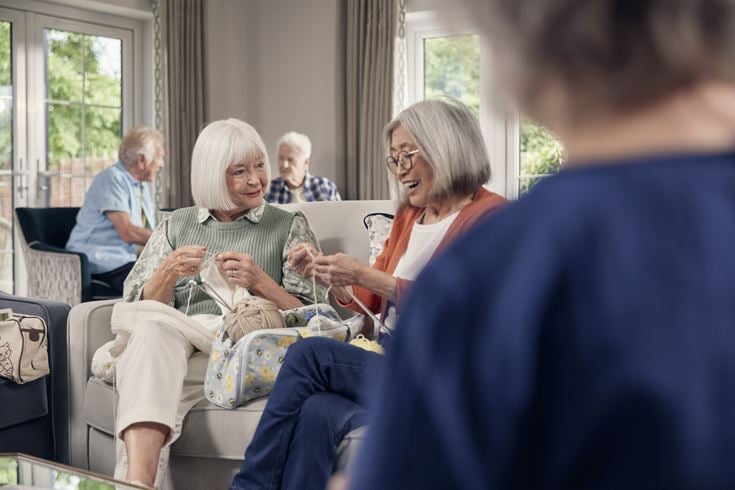 Two retired ladies knit and crochet garments.