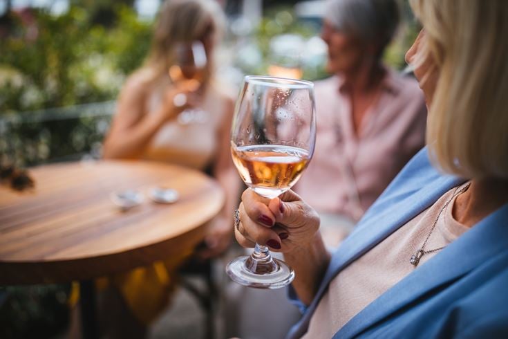 A group of retirees sampling wine at a charity tasting event.