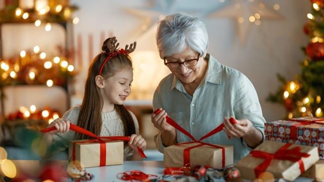 a woman and grandchild wrapping christmas gifts