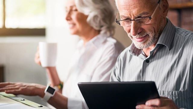 a man and a woman looking at a tablet
