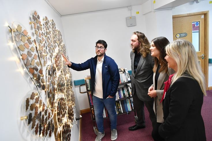 a group of people looking at a model of a building