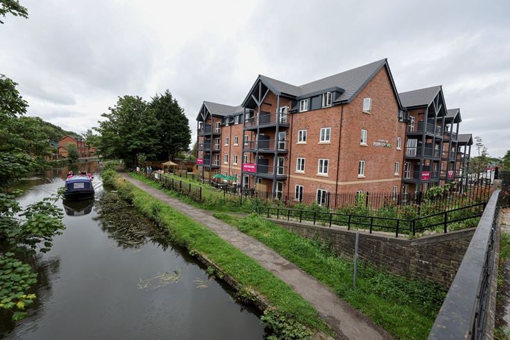a canal with a boat in it and buildings along it