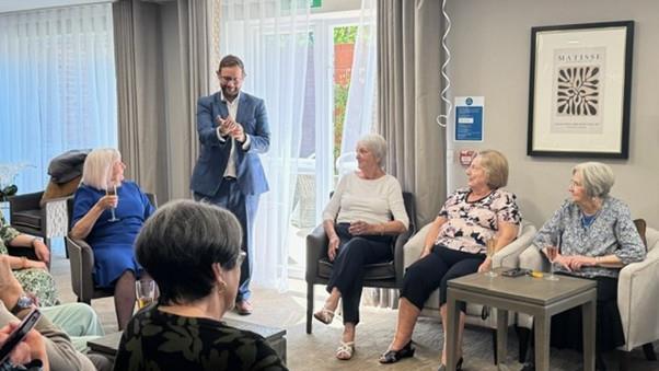 a person speaking to a group of people in a room