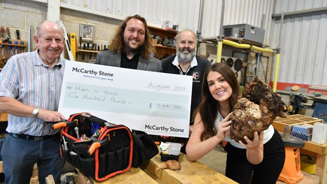 Staff from McCarthy & Stone present the Men in Sheds Group in Blidworth with a donation.