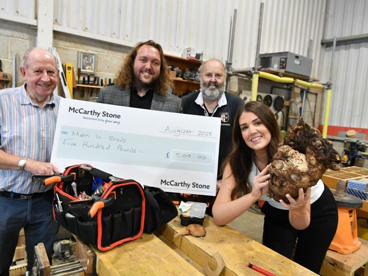 Staff from McCarthy & Stone present the Men in Sheds Group in Blidworth with a donation.