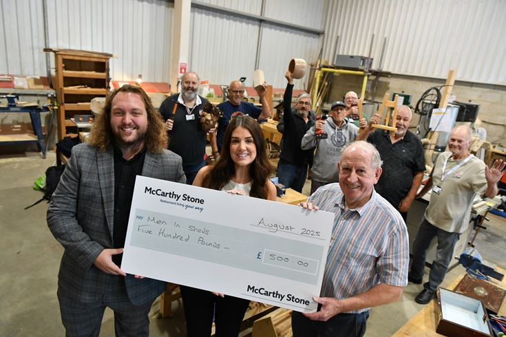 Staff from McCarthy & Stone present the Men in Sheds Group in Blidworth with a donation.