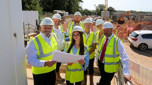 a group of people wearing hardhats and holding papers