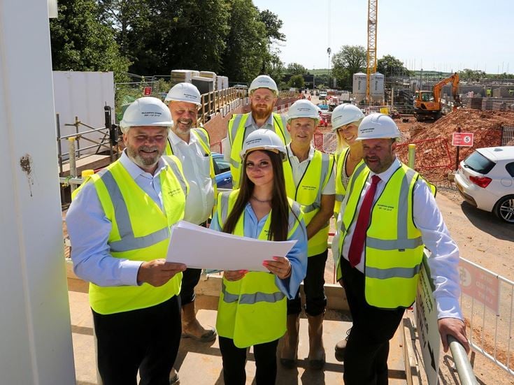 a group of people wearing hardhats and holding papers