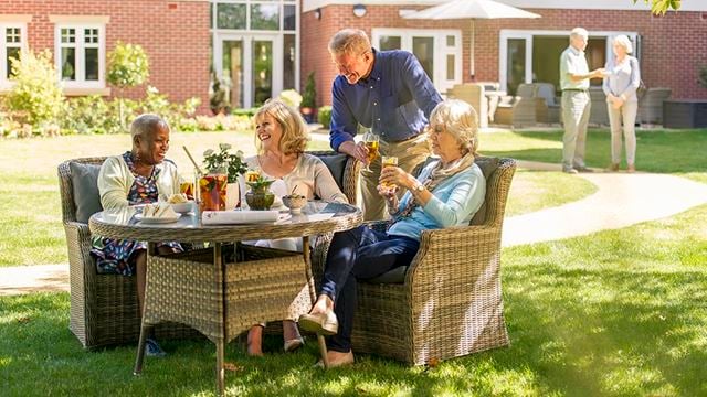 a group of people sitting around a table outside