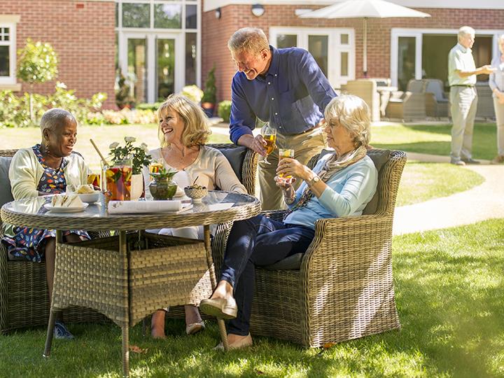 a group of people sitting around a table outside