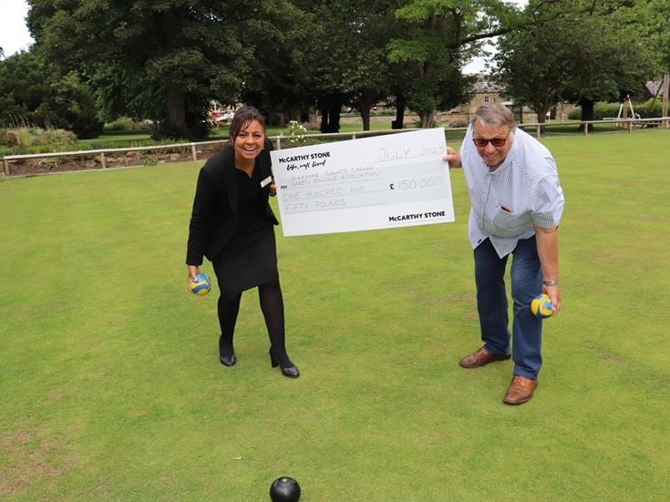 a man and woman standing next to a sign on a golf course