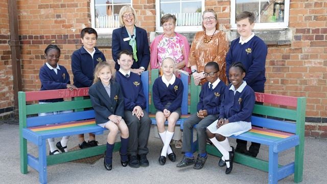 a group of people sitting on a bench outside a building