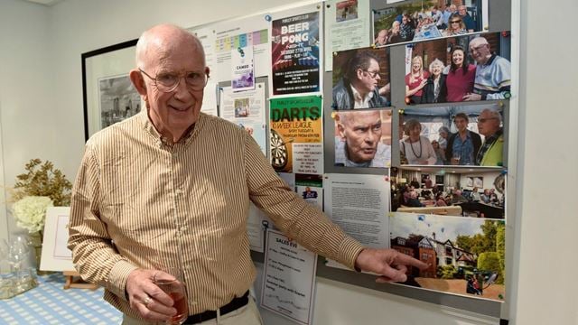Mike points to and image of his old home from his McCarthy & Stone retirement home in Purley, London