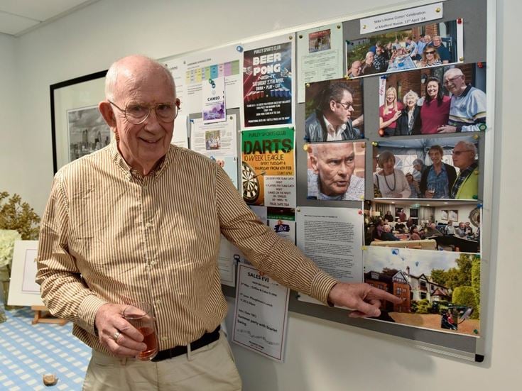 Mike points to and image of his old home from his McCarthy & Stone retirement home in Purley, London