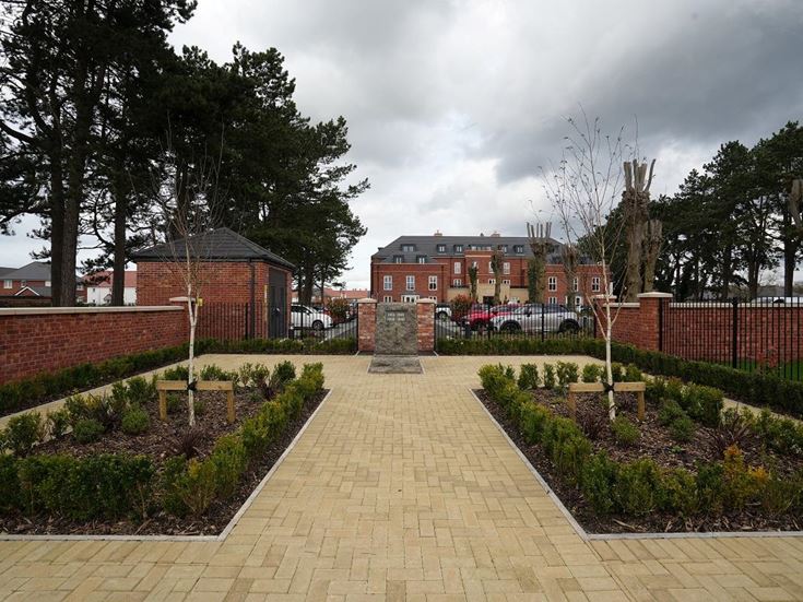 a brick walkway with a brick fence and a brick wall and trees
