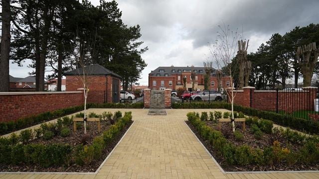a brick walkway with a brick fence and a brick wall and trees