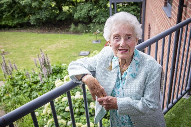 Ross leaning on a balcony overlooking a garden