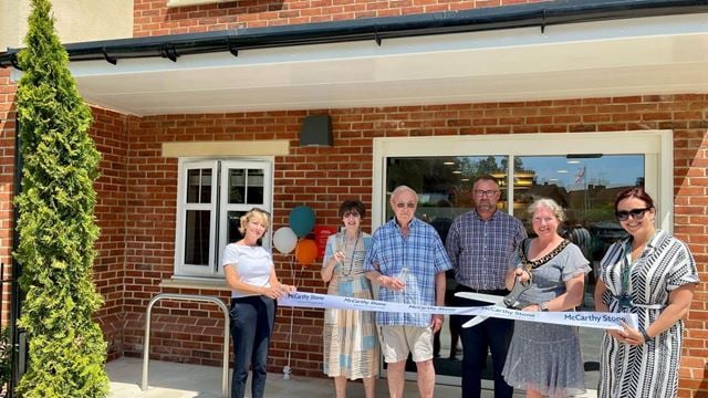 Councillor Penny Flux cutting the ribbon at the grand opening of Flora Place.