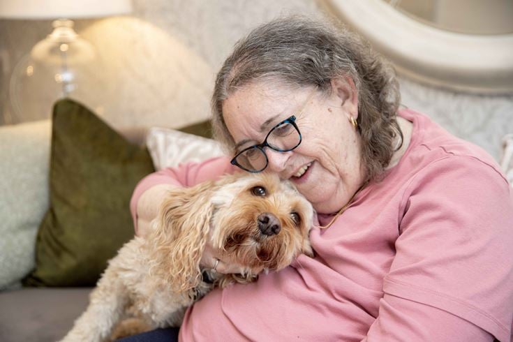 a person lying on a couch with a dog