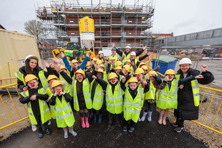 a group of people in safety vests posing for a photo