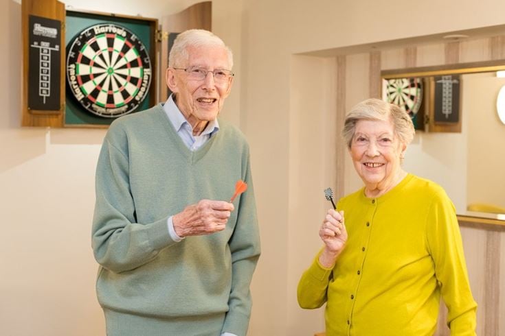 Jenny Hurford and Michael Lambert playing darts together at Ridgeway Court, enjoying their time and companionship