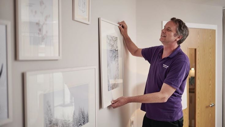A McCarthy & Stone handyperson helps someone settle in as part of Smooth Move