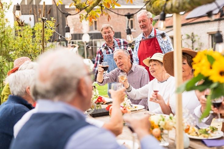 A group of older people sharing an outdoor lunch