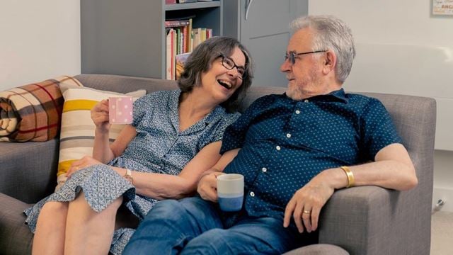 Mr and Mrs Gordon sitting on their couch