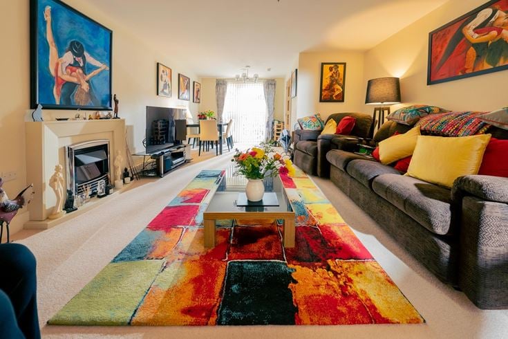 a living room with a rug and a coffee table