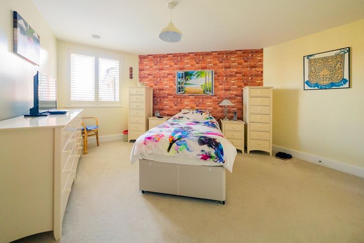 a bedroom with a bed desk and computer