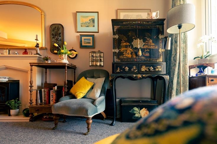 a living room with a mirror and a chair