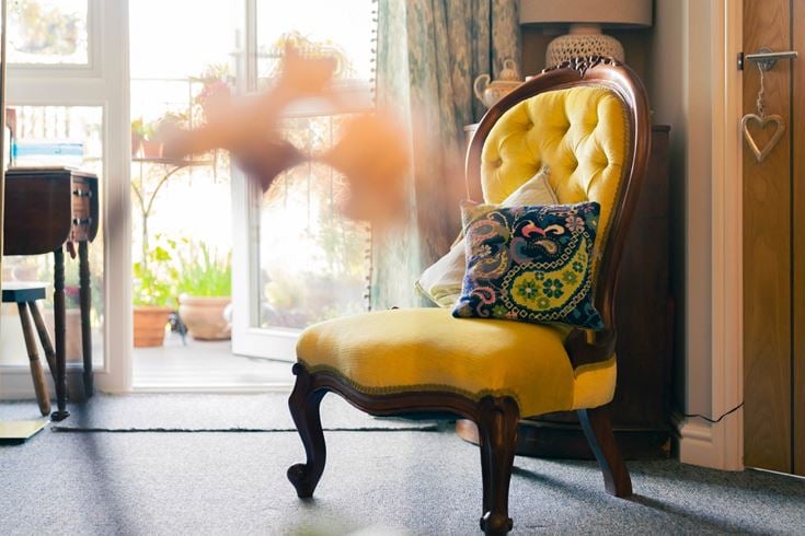 a yellow chair with a pillow