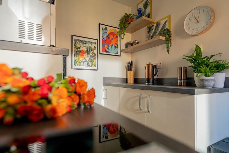 a kitchen with a clock and flowers