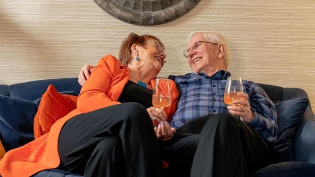 a man and woman sitting on a couch and laughing