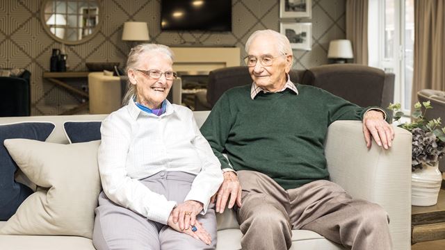 an older couple sitting on a couch