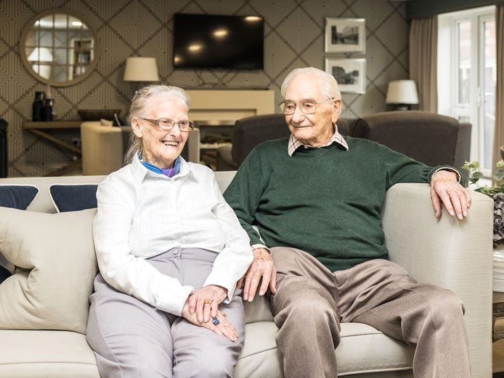 an older couple sitting on a couch