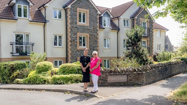 Two woman standing in front of a McCarthy & Stone retirement property