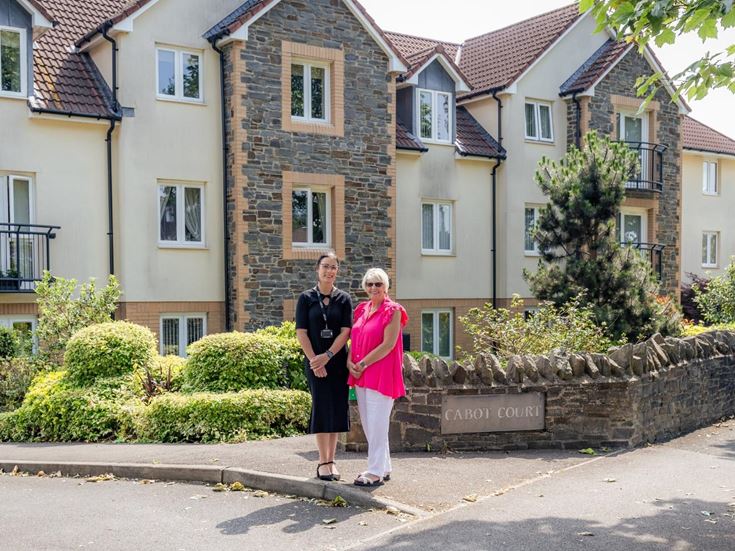 Two woman standing in front of a McCarthy & Stone retirement property