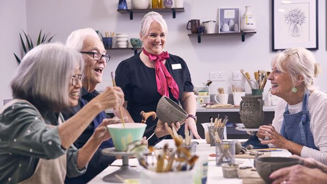 A group of retirees and the developments Estates Manager at a craft session within on of the retirement living plus developments. 