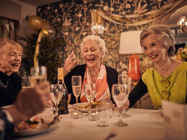a group of women sitting at a table with wine glasses
