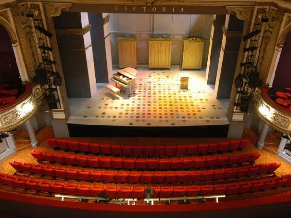 a room with a large stage and a large stage with a group of people in the front