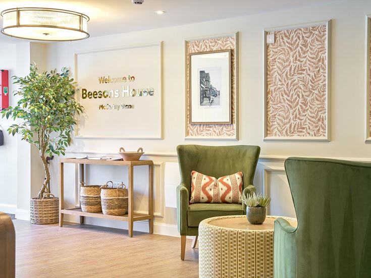 a room with green chairs and a table with a plant on it