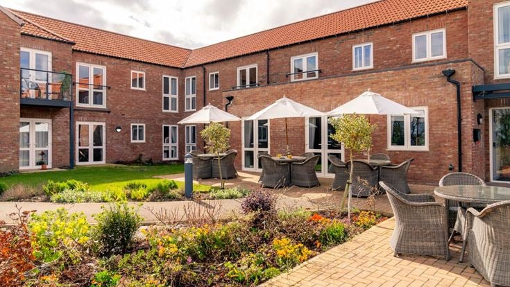 a brick building with a patio and tables and chairs
