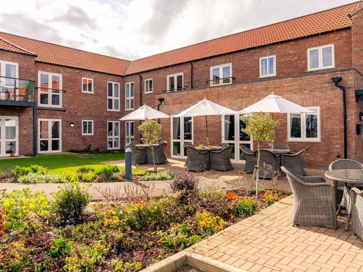 a brick building with a patio and tables and chairs